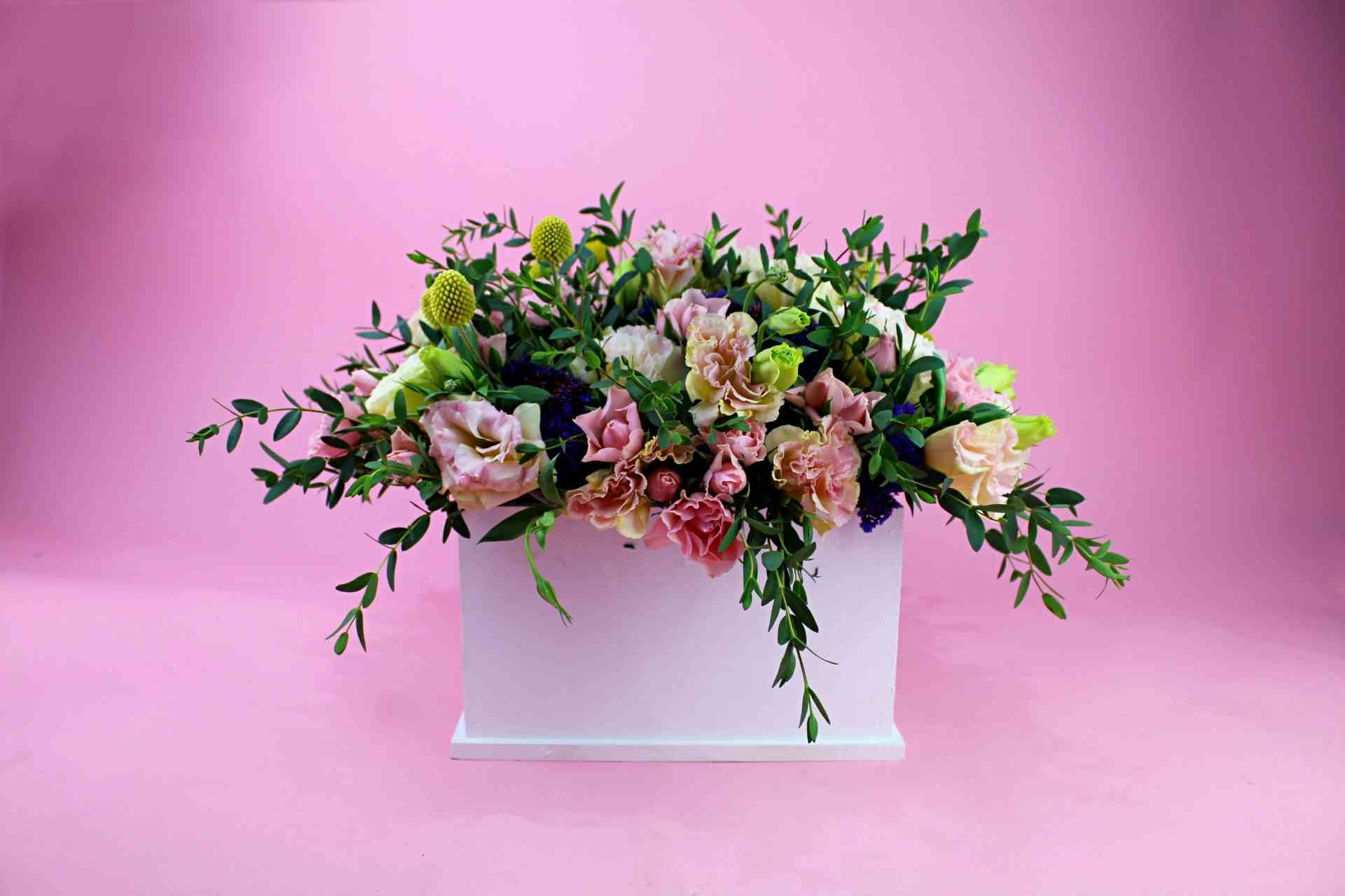 Adorno floral de lisianthus y mini rosas acompañado de follajes diversos