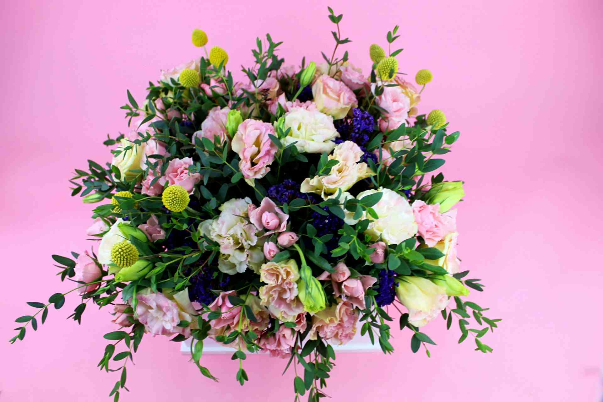 Adorno floral de lisianthus y mini rosas acompañado de follajes diversos